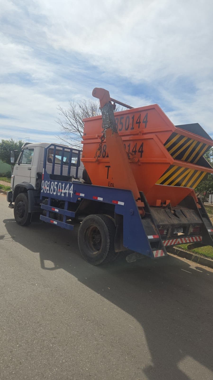 Caminhão poliguindaste da Tiro Entulho transportando caçamba