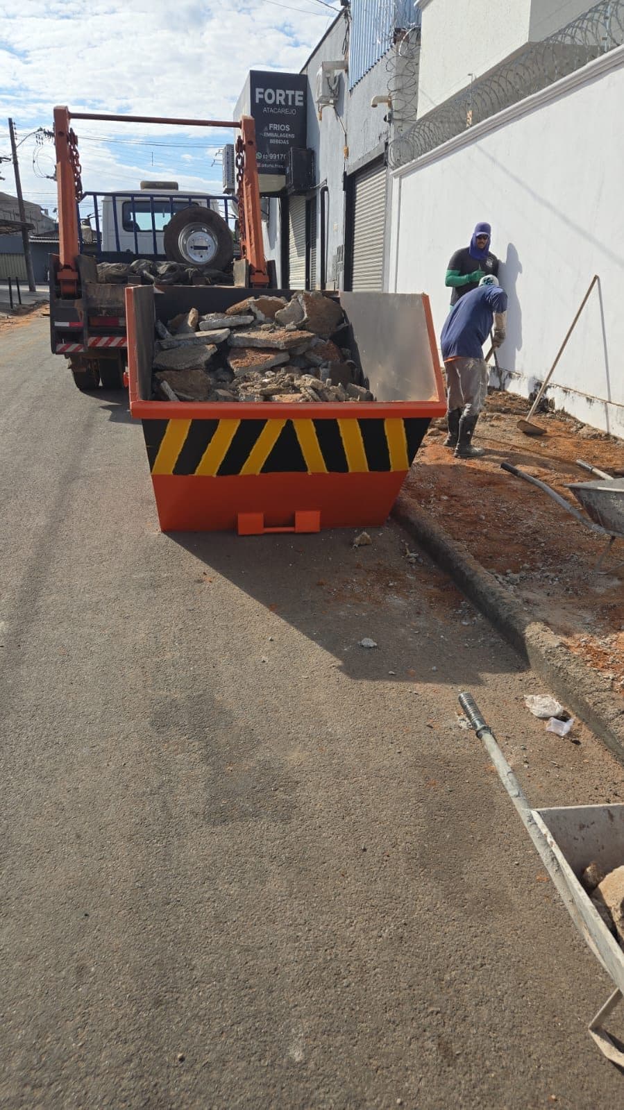 Caçamba recebendo entulho de demolição em obra